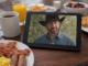 Chuck Norris en una tablet sobre una mesa con desayuno americano, representando su fenómeno viral en internet