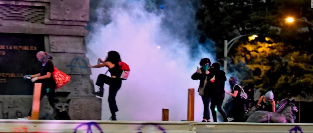 Protesta feminista con disturbios y humo en vía pública durante manifestación nocturna