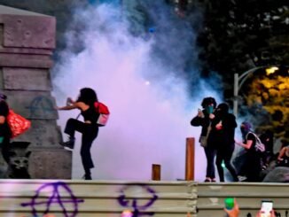 Protesta feminista con disturbios y humo en vía pública durante manifestación nocturna