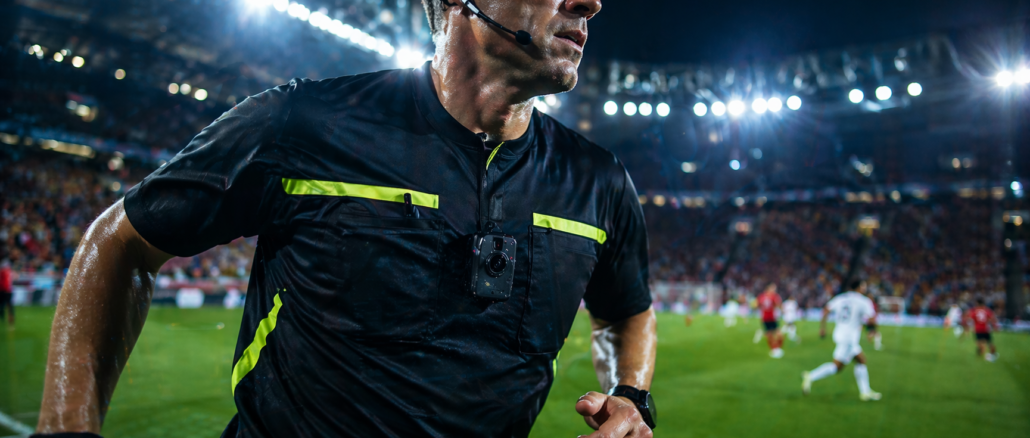 cámaras en árbitros fútbol durante partido con cámara corporal en el pecho en un estadio iluminado