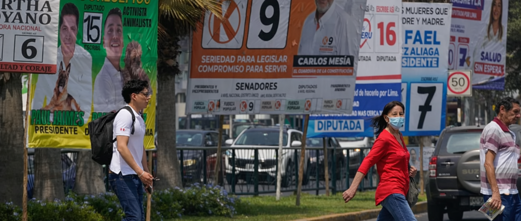 votantes caminando frente a propaganda electoral en Lima durante elecciones en Perú 2026