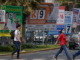 votantes caminando frente a propaganda electoral en Lima durante elecciones en Perú 2026
