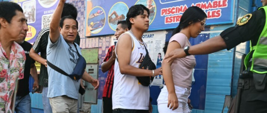 votantes en fila durante elecciones en Perú con presencia policial en centro de votación