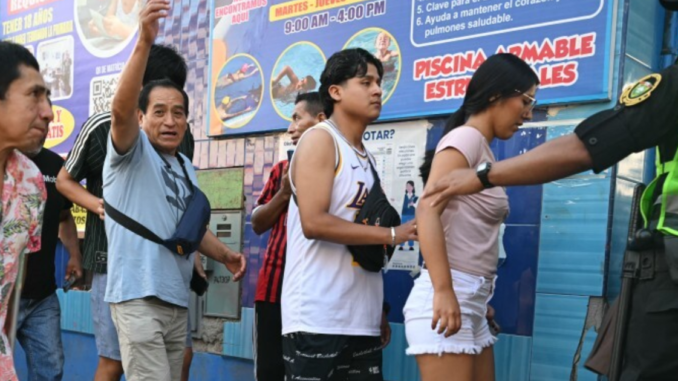 votantes en fila durante elecciones en Perú con presencia policial en centro de votación