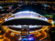 Vista aérea nocturna del Estadio Nacional de Costa Rica durante un evento masivo en San José.