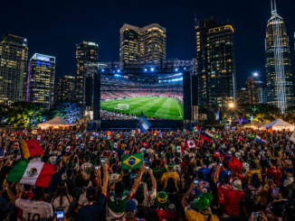 Fan zones 2026 con miles de aficionados viendo partidos del Mundial en pantallas gigantes durante la noche
