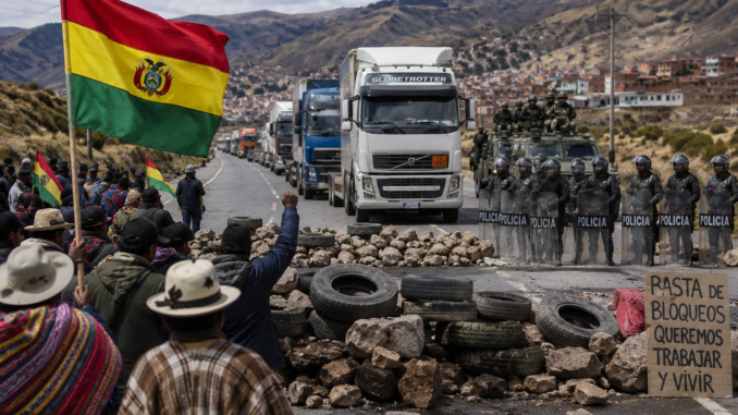 Manifestantes bloquean una carretera en Bolivia mientras policías y militares se preparan para despejar rutas afectadas por la crisis política.