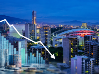 Vista panorámica de San José con gráficos financieros descendentes que representan la desaceleración económica y la contracción del mercado laboral en Costa Rica.