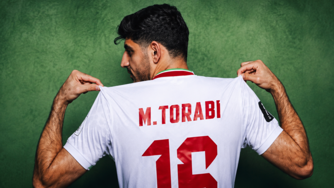 Mehdi Torabi, jugador de la selección de Irán, mostrando su camiseta durante el Mundial 2026.