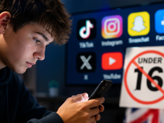 Adolescente utilizando un teléfono móvil mientras Reino Unido impulsa una ley para prohibir el acceso de menores de 16 años a redes sociales.