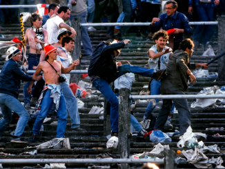 Aficionados violentos conocidos como hooligans se enfrentan en las gradas de un estadio durante un partido de fútbol en Inglaterra.