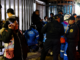 Policías y paramédicos atienden una emergencia mientras varias personas observan en las afueras de un edificio durante un operativo nocturno.