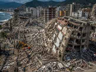 Vista aérea de edificios colapsados y equipos de rescate trabajando entre los escombros tras el terremoto que devastó La Guaira, Venezuela.