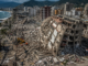 Vista aérea de edificios colapsados y equipos de rescate trabajando entre los escombros tras el terremoto que devastó La Guaira, Venezuela.