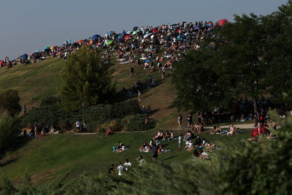 Personas se reúnen en el parque El Cerro del Tío Pío de Madrid para observar el eclipse solar total.
